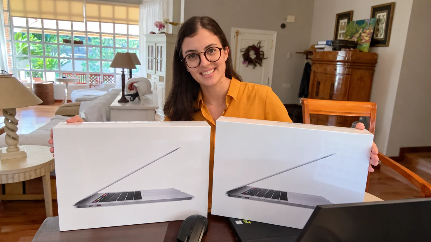 Carla smiling with two laptop boxes