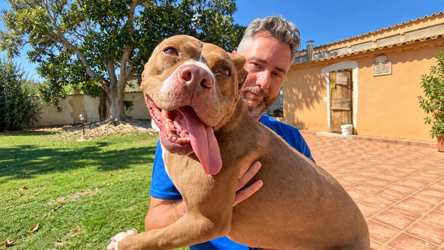 Martín embracing a large dog